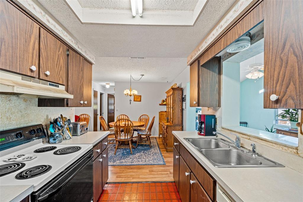 9061 Byron Street Spring Hill, FL 34606 - Photo 20 of 43 a kitchen with stainless steel appliances granite countertop a sink stove and cabinets