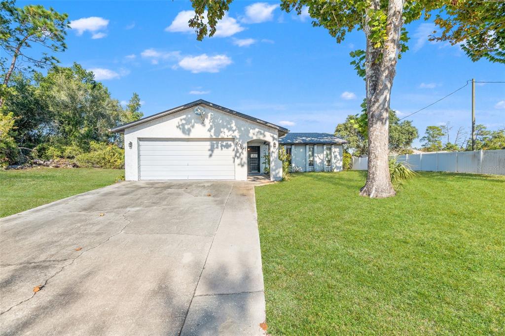 9061 Byron Street Spring Hill, FL 34606 - Photo 2 of 43 a front view of a house with a yard and garage