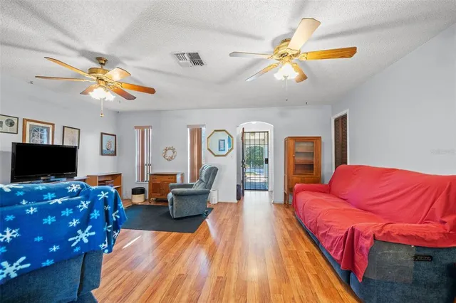 a living room with furniture a flat screen tv and a chandelier