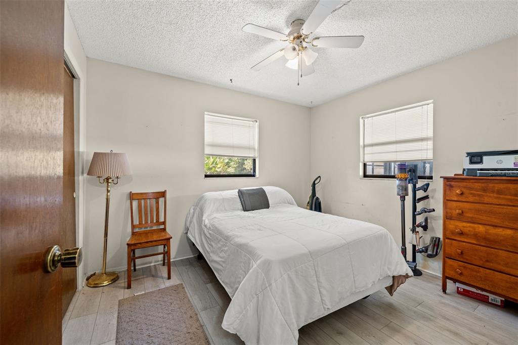 9061 Byron Street Spring Hill, FL 34606 - Photo 23 of 43 a bedroom with a bed and a chandelier