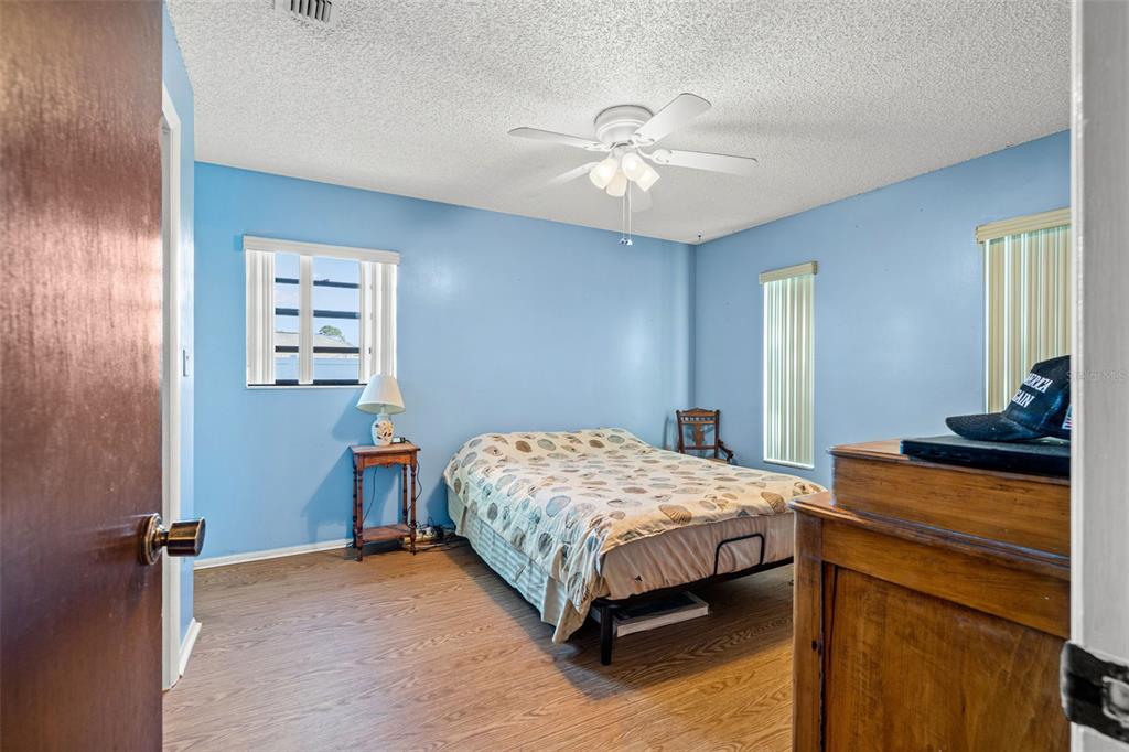 9061 Byron Street Spring Hill, FL 34606 - Photo 9 of 43 a bedroom with a bed and a chandelier