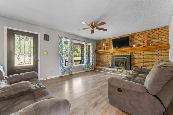 a living room with furniture a fireplace and a flat screen tv