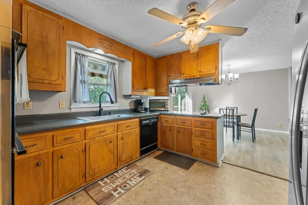 a kitchen with granite countertop a sink cabinets and window