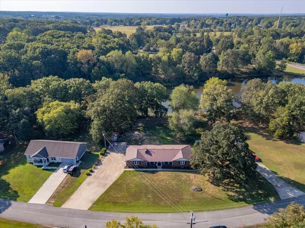 an aerial view of residential houses with outdoor space and lake view