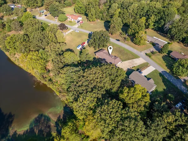 an aerial view of residential houses with outdoor space and lake view