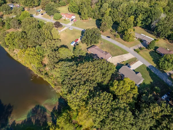 an aerial view of lake and residential houses with outdoor space