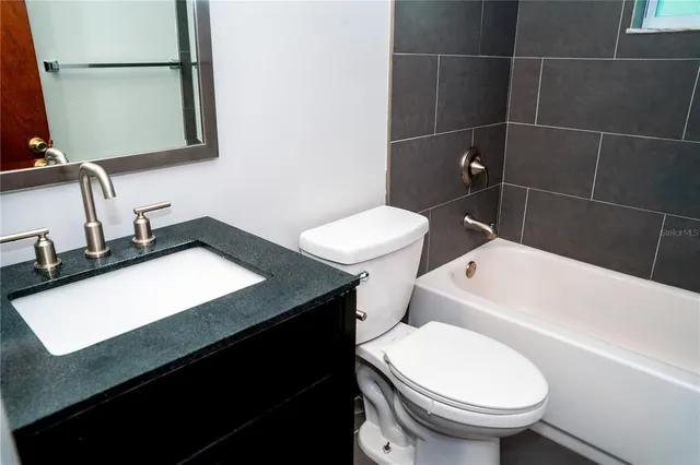 a bathroom with a sink toilet vanity and tub