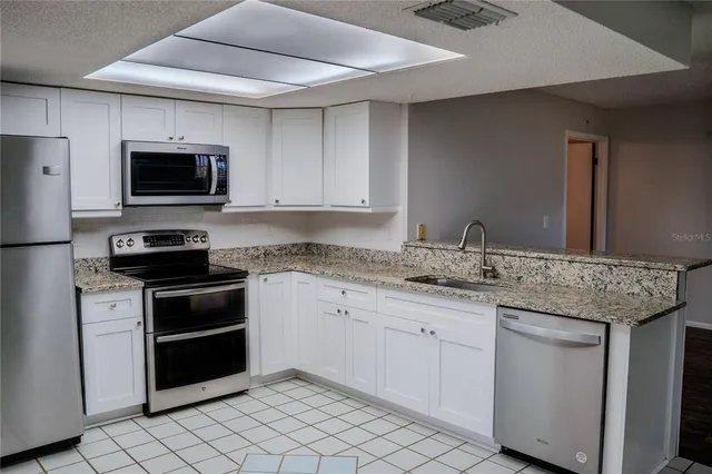 a kitchen with granite countertop a sink and a stove top oven