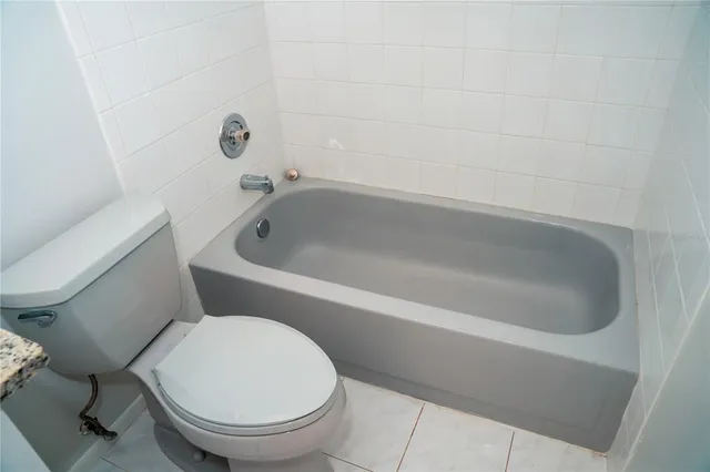 a white toilet sitting next to a bath tub