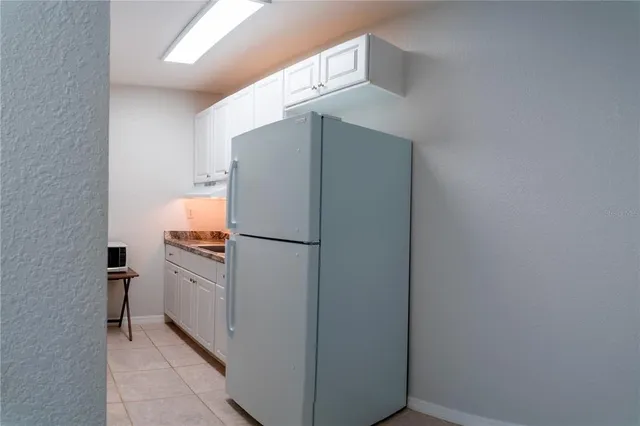 a white refrigerator freezer and a stove sitting inside of a kitchen