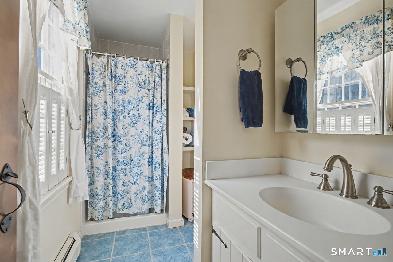 226 Middlesex Avenue Chester, CT 06412 - Photo 22 of 40 a bathroom with a granite countertop sink a mirror and shower