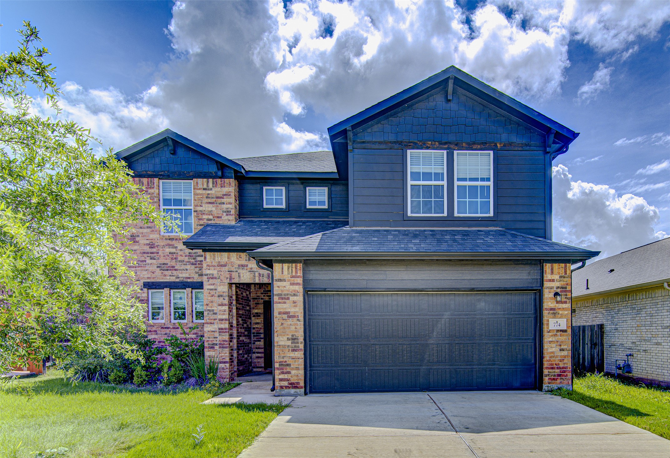 774 Cherrystone Loop Buda, TX 78610 - Photo 1 of 38 Bold blue siding and brick accents define this welcoming modern residence.