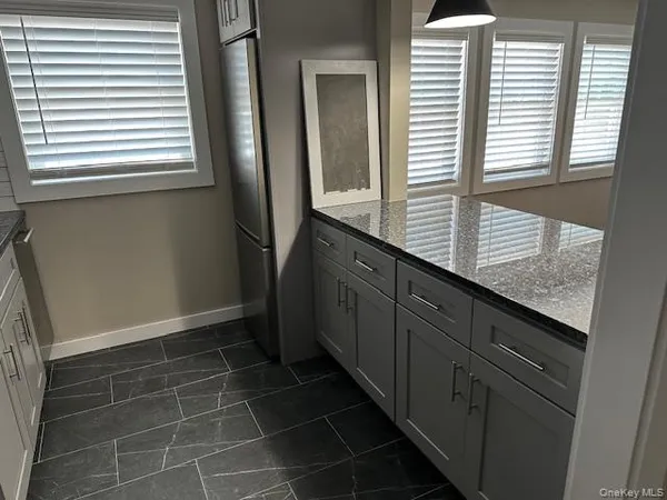 a bathroom with a granite countertop sink and window