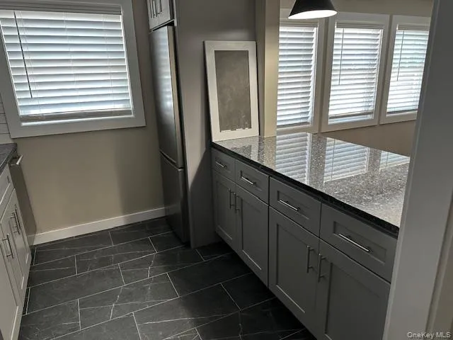 a bathroom with a granite countertop sink and window
