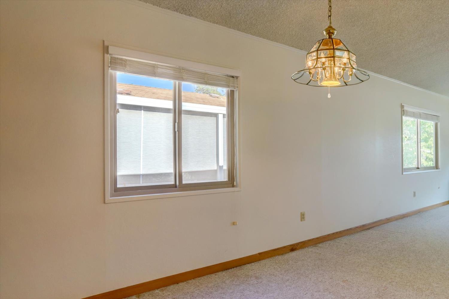 10046 Dalewood Way Grass Valley, CA 95949 - Photo 13 of 68 an empty room with windows and chandelier fan