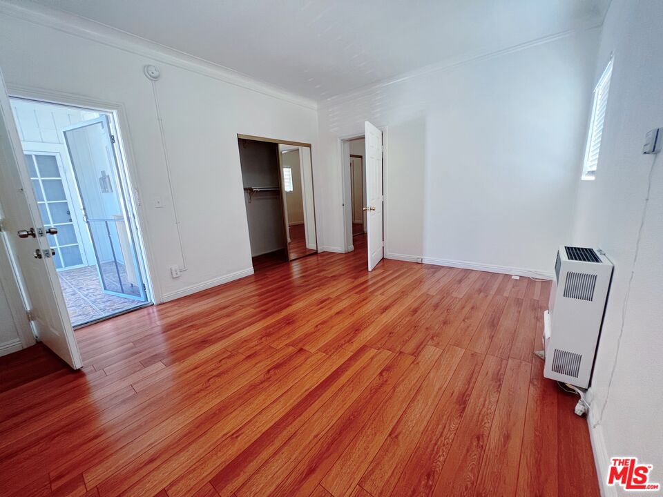 2740 James M Wood Boulevard Los Angeles, CA 90006 - Photo 2 of 15 a view of an empty room with wooden floor and a window