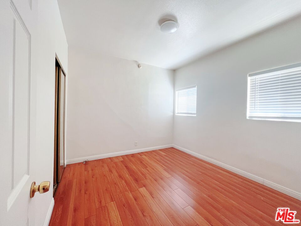 2740 James M Wood Boulevard Los Angeles, CA 90006 - Photo 5 of 15 an empty room with wooden floor and windows
