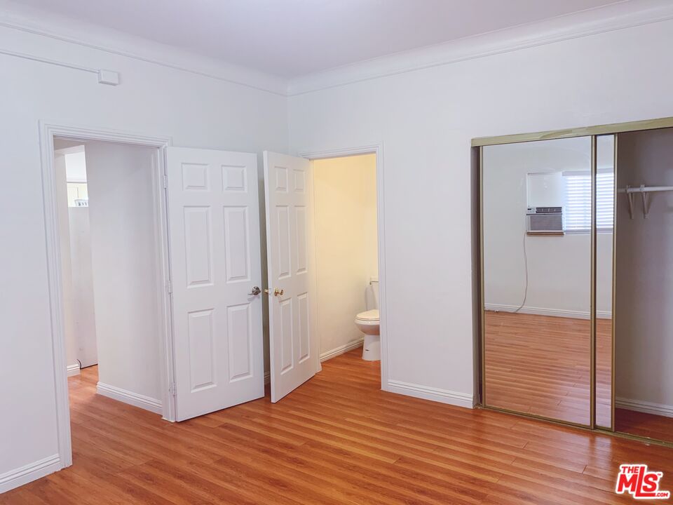 2740 James M Wood Boulevard Los Angeles, CA 90006 - Photo 10 of 15 a view of an empty room with wooden floor and a bathroom