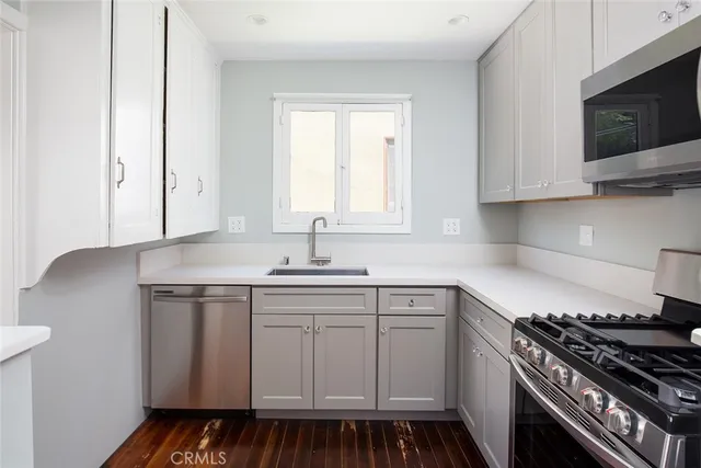 a kitchen with stainless steel appliances a sink stove and cabinets