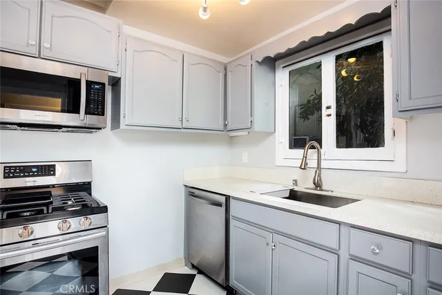 a kitchen with stainless steel appliances granite countertop a sink stove and microwave
