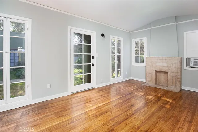a view of empty room with wooden floor and fireplace