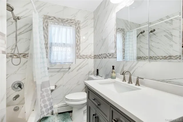 a bathroom with a sink toilet vanity and shower