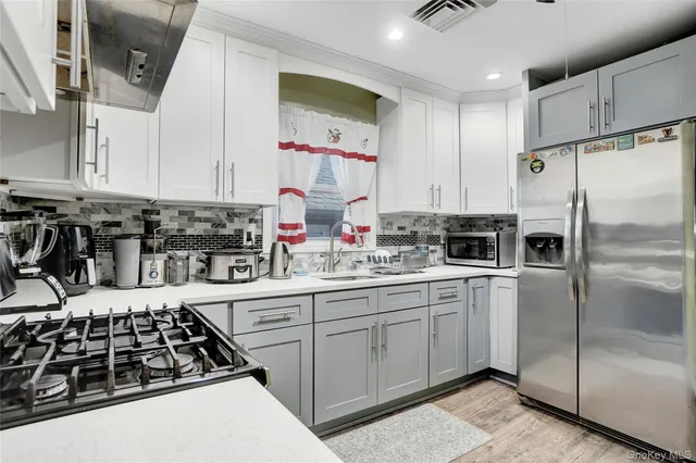 a kitchen with stainless steel appliances a stove a sink and a refrigerator