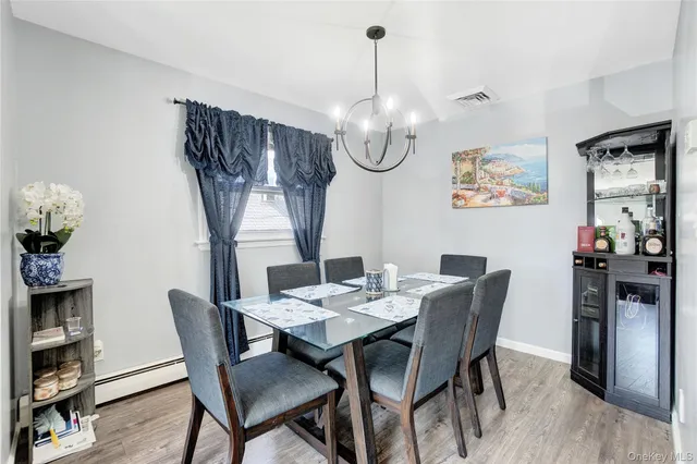 a view of a dining room with furniture a chandelier and wooden floor