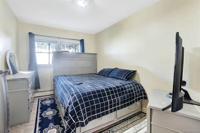 a bedroom with a bed and a large mirror next to a window