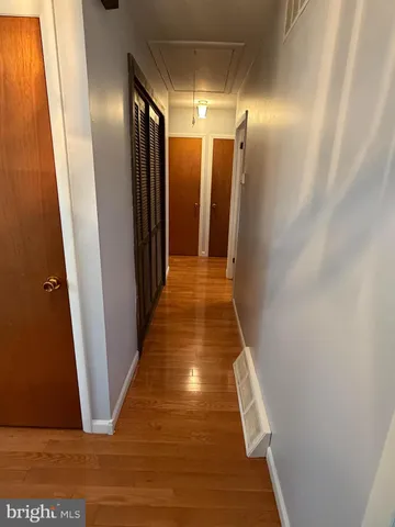 a kitchen with stainless steel appliances granite countertop a sink a stove a refrigerator cabinets and a dining table with wooden floor