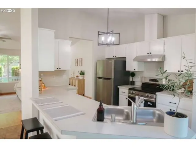 a kitchen with cabinets appliances and a window