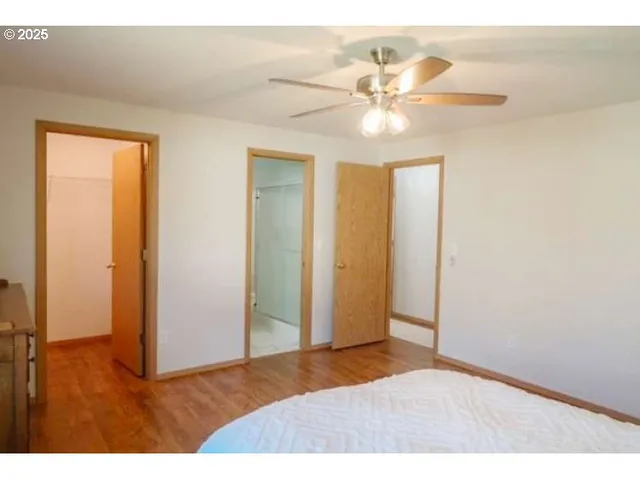a bedroom with a bed and a ceiling fan