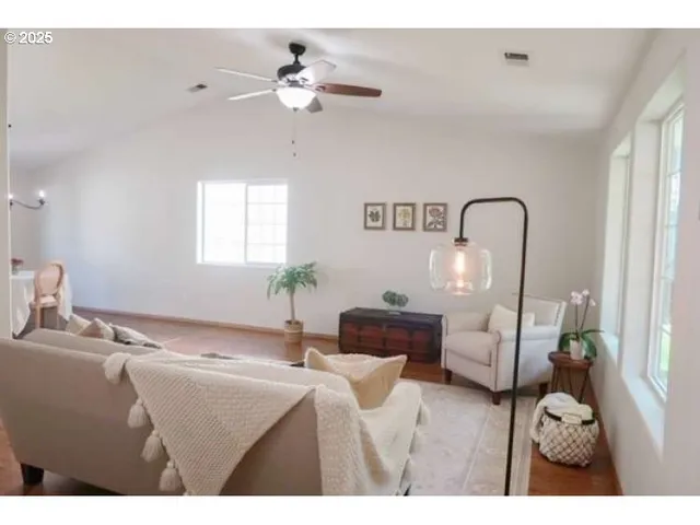 a living room with furniture a large window and a rug