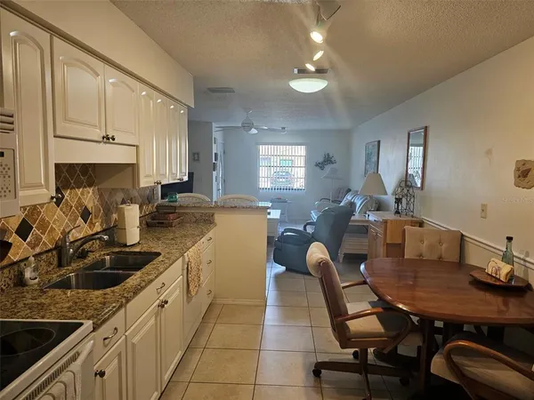 a kitchen with a table chairs sink and cabinets