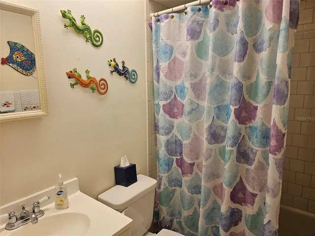 a bathroom with a sink and mirror with shower