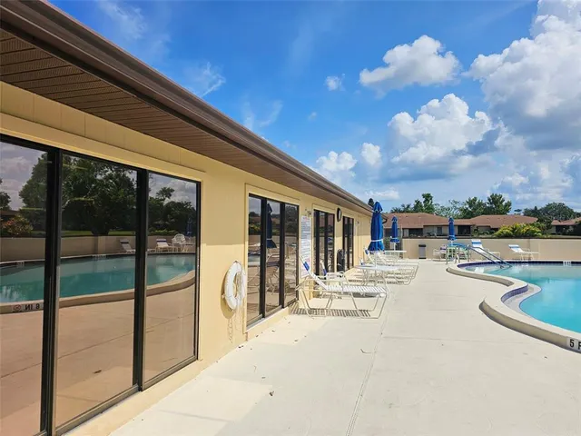 a swimming pool with outdoor seating and yard in the back