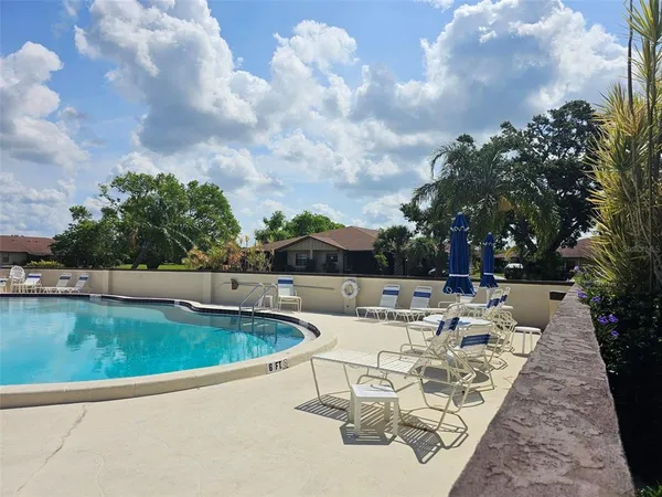 a view of backyard with swimming pool and outdoor seating