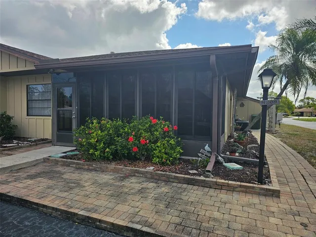 a bunch of flowers sitting in front of yellow house
