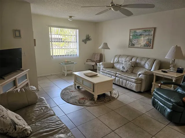 a living room with furniture a flat screen tv and a window