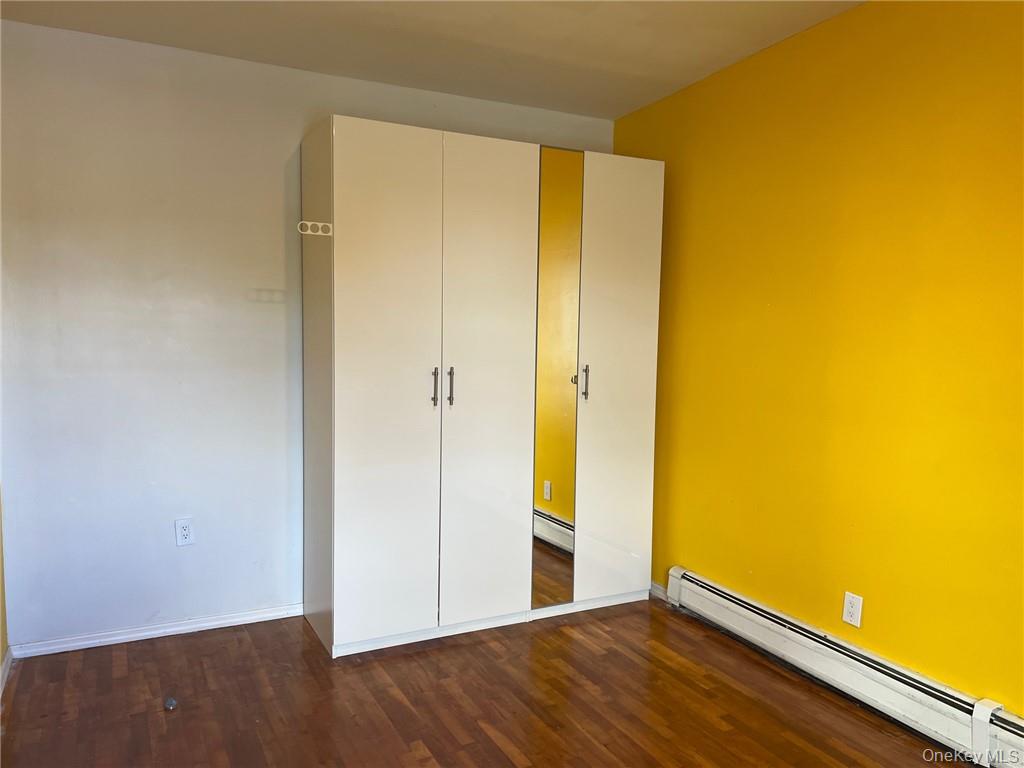 708 Silver Lake-Scotchtown Road Middletown, NY 10941 - Photo 24 of 25 Unfurnished bedroom featuring a closet, dark hardwood / wood-style flooring, and a baseboard radiator