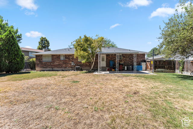 8843 Capernaum Road West Jordan, UT 84088 - Photo 24 of 31 Back of house featuring brick siding, a patio area, and a fenced backyard