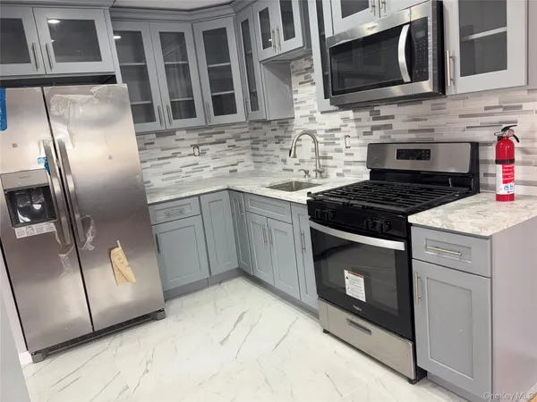 a kitchen with stainless steel appliances granite countertop a stove microwave and refrigerator