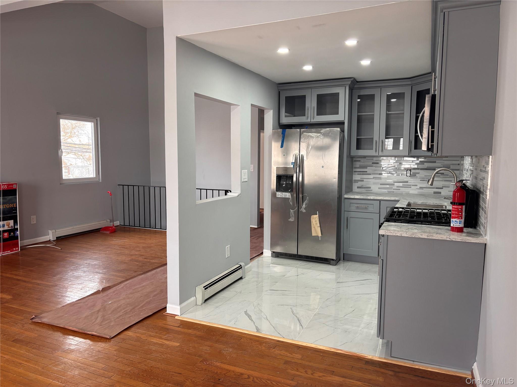 145-01 223rd Street, Unit 2 Queens, NY 11413 - Photo 8 of 12 a kitchen with stainless steel appliances granite countertop a refrigerator and a sink