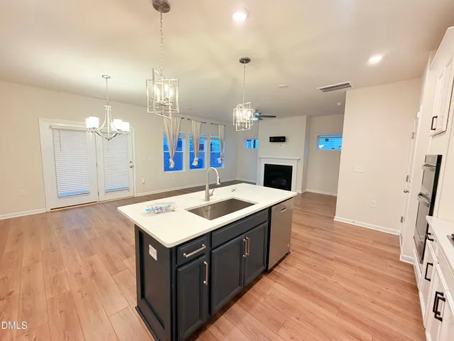 a kitchen with a stove and a wooden floor