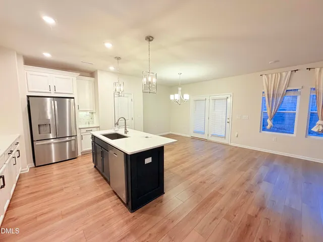 a kitchen with stainless steel appliances granite countertop a sink and a refrigerator