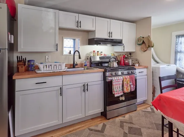 a kitchen with stainless steel appliances granite countertop a sink stove and cabinets
