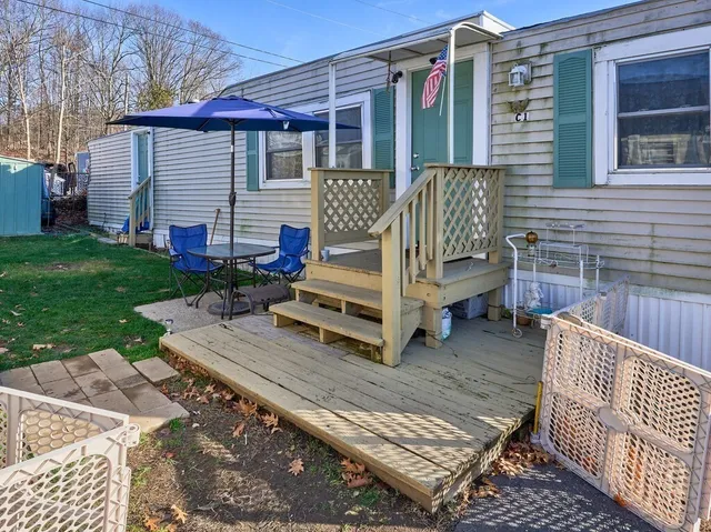 a view of a chair and tables in the back yard of the house