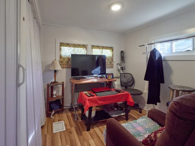 a living room with furniture a flat screen tv and a window