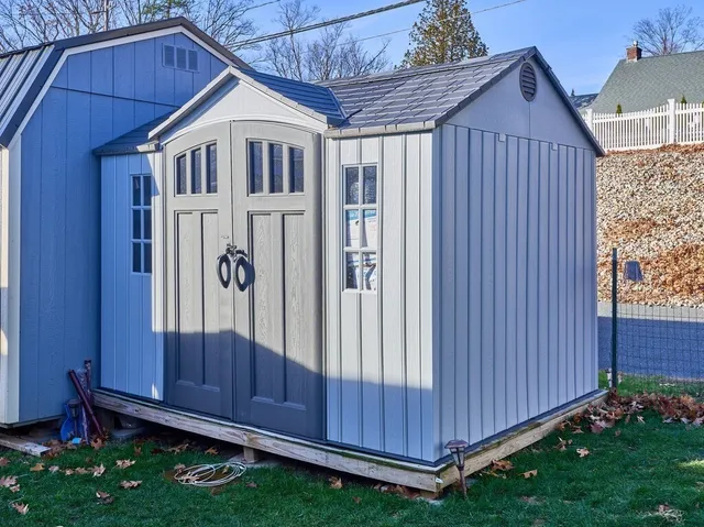 a view of a small house with wooden fence