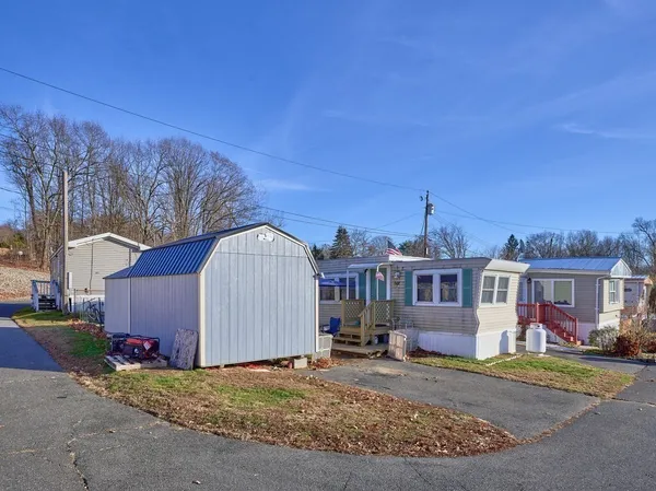 a view of a house with backyard and trees
